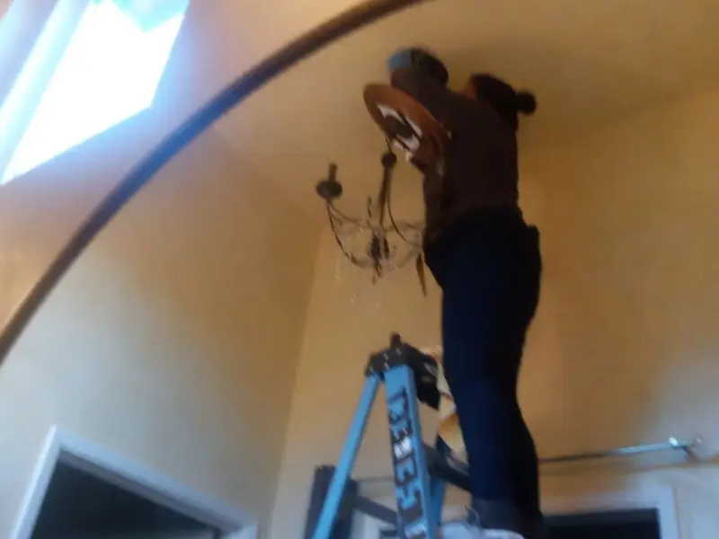 Electrician installing a chandelier in a Lebanon residence